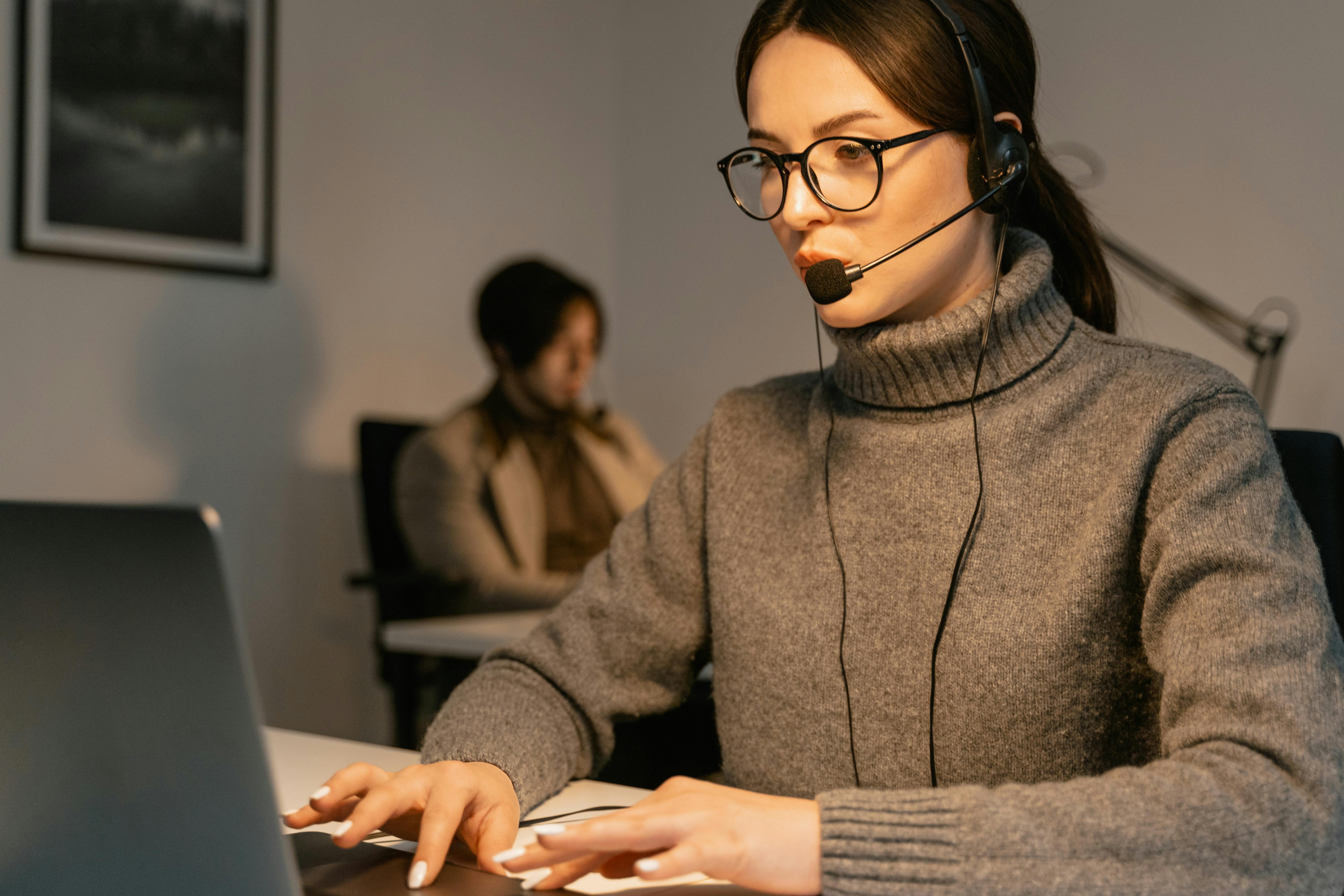Professional woman wearing headset working in customer support, focused on her tasks.